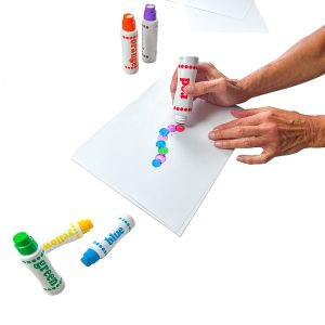 Une personne adulte utilise l'ensemble Do-A-dot-Art sur une feuille blanche.
